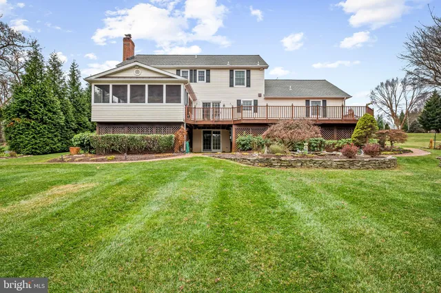 a front view of a house with a garden and trees