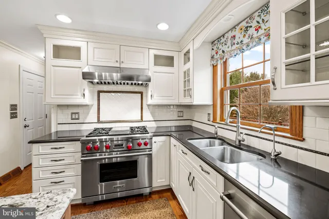 a kitchen with granite countertop a stove and a sink