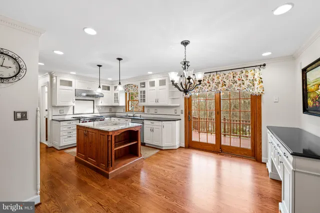 a kitchen with stainless steel appliances granite countertop a stove a sink dishwasher a refrigerator and cabinets with wooden floor