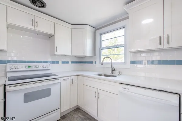 a white kitchen with granite countertop white cabinets and white appliances