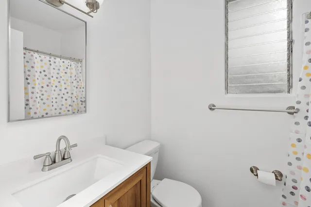 a bathroom with a sink mirror and toilet