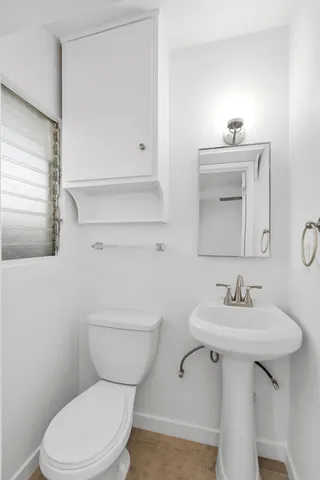 a bathroom with a sink toilet and mirror