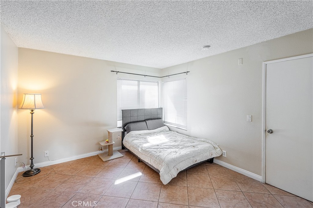 14610 Erwin Street, Unit 212 Van Nuys, CA 91411 - Photo 11 of 16 a bedroom with a bed and a table in it