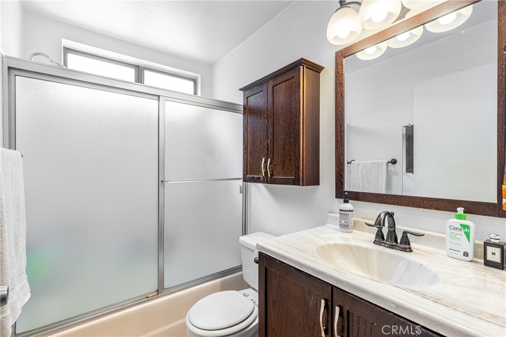 14610 Erwin Street, Unit 212 Van Nuys, CA 91411 - Photo 14 of 16 a bathroom with a granite countertop sink toilet and shower