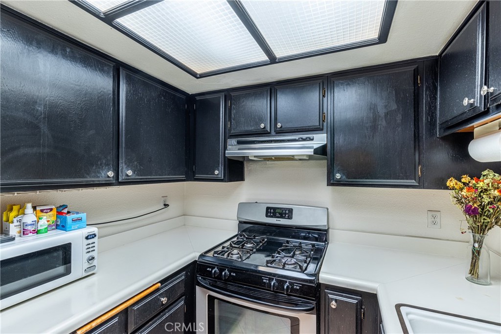 14610 Erwin Street, Unit 212 Van Nuys, CA 91411 - Photo 5 of 16 a kitchen with granite countertop a stove and a refrigerator