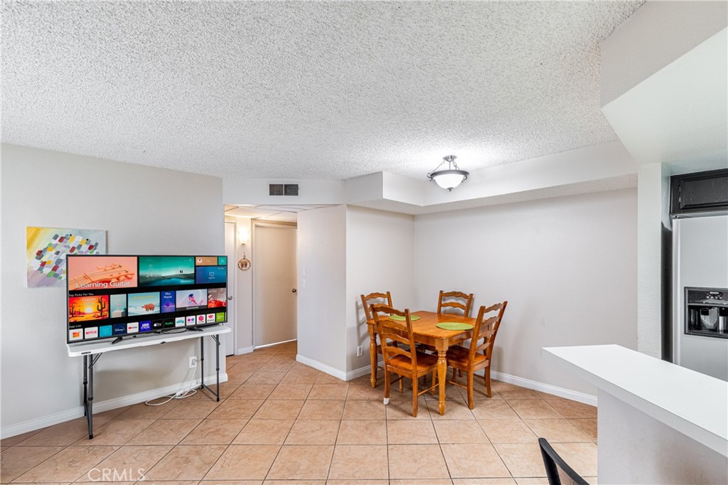 14610 Erwin Street, Unit 212 Van Nuys, CA 91411 - Photo 6 of 16 a dining room with furniture and a flat screen tv