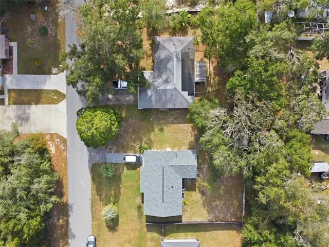 an aerial view of residential houses with outdoor space and trees