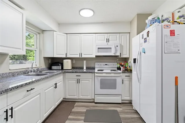 a kitchen with white cabinets and white appliances