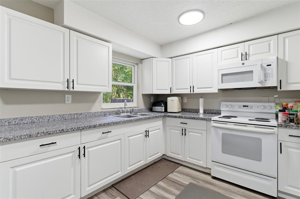 150 South Rooks Avenue Inverness, FL 34453 - Photo 7 of 30 a kitchen with stainless steel appliances granite countertop white cabinets sink and window