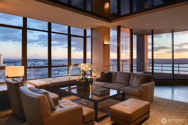a living room with furniture and floor to ceiling windows