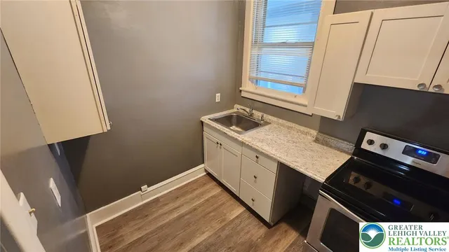 a kitchen with a sink stove and cabinets