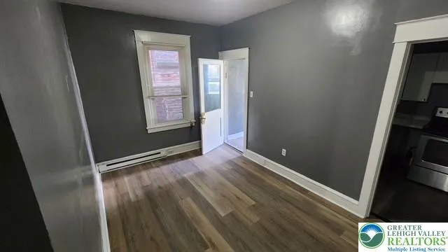a view of an empty room and wooden floor