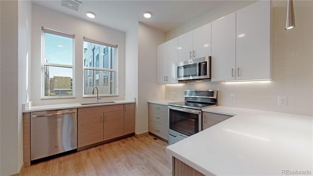 a kitchen with stainless steel appliances granite countertop a stove a sink and a microwave