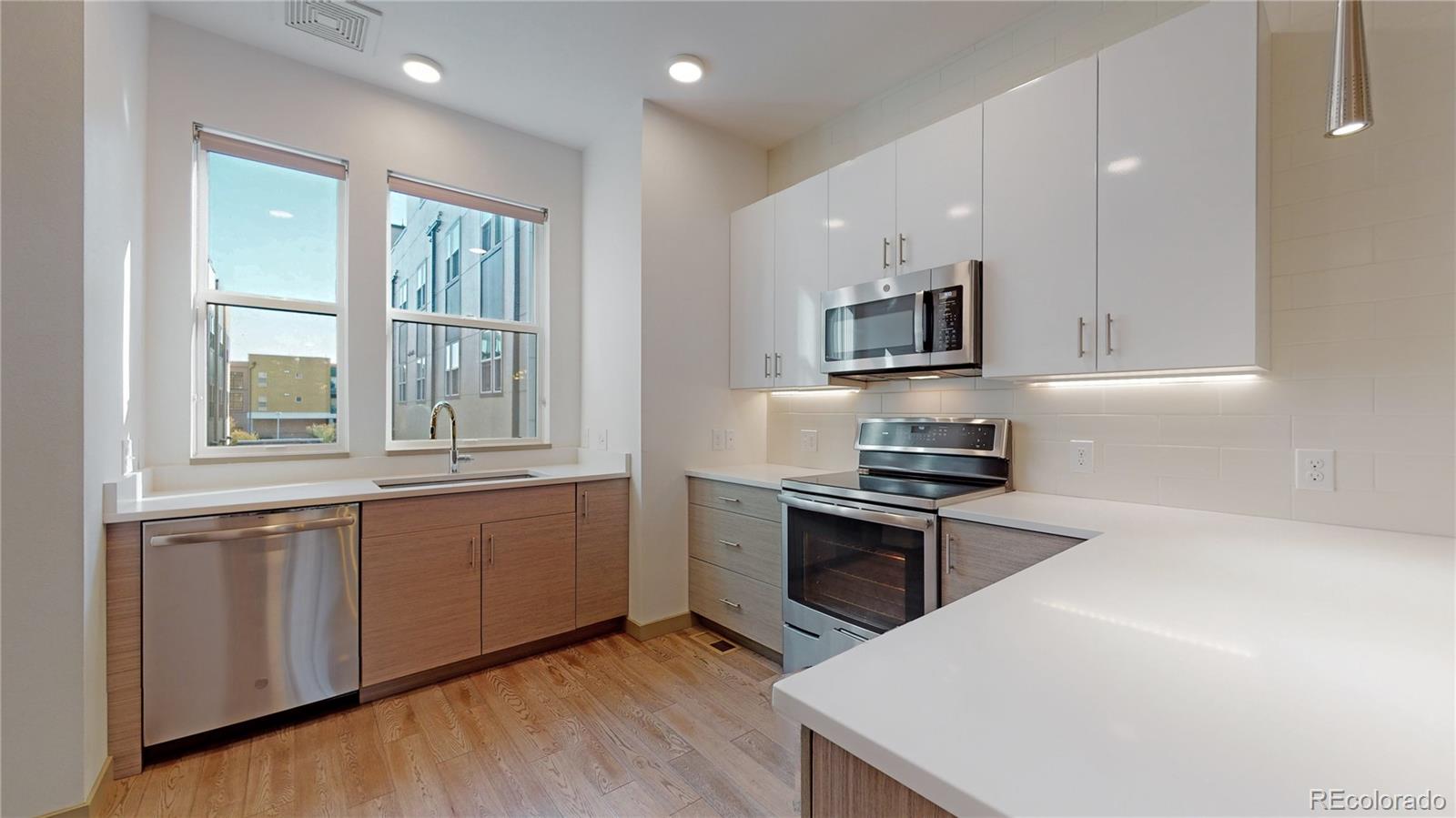 385 22nd Street, Unit 4 Denver, CO 80205 - Photo 12 of 40 a kitchen with stainless steel appliances granite countertop a stove a sink and a microwave