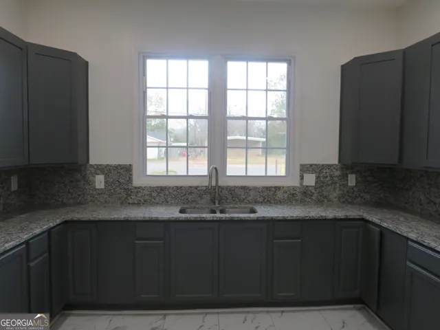 a kitchen with granite countertop a stove and a sink