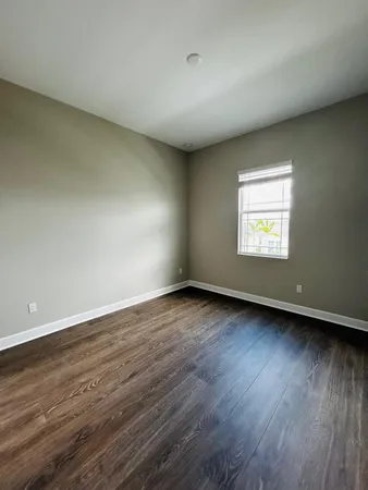 a view of a big room with wooden floor and windows