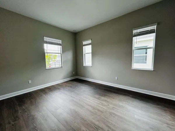 a view of an empty room with wooden floor