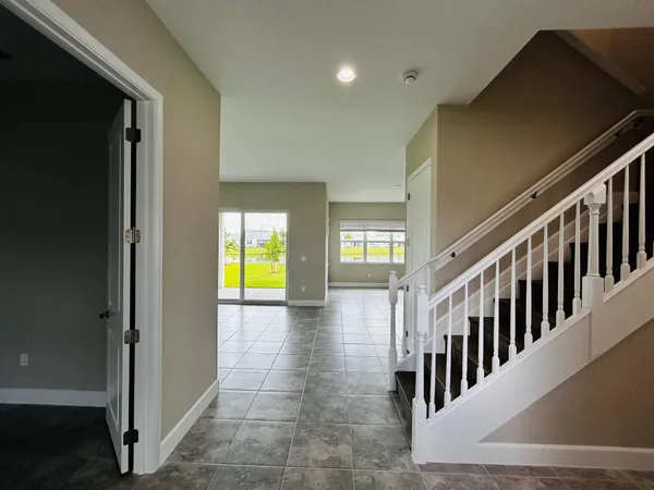 a view of an empty room with kitchen and a window
