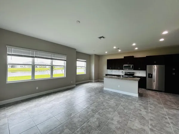 a kitchen with stainless steel appliances granite countertop a sink a stove and a refrigerator