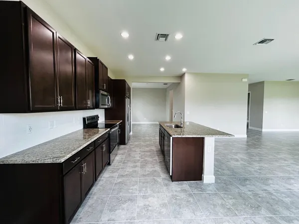 a kitchen with stainless steel appliances granite countertop a sink and a stove