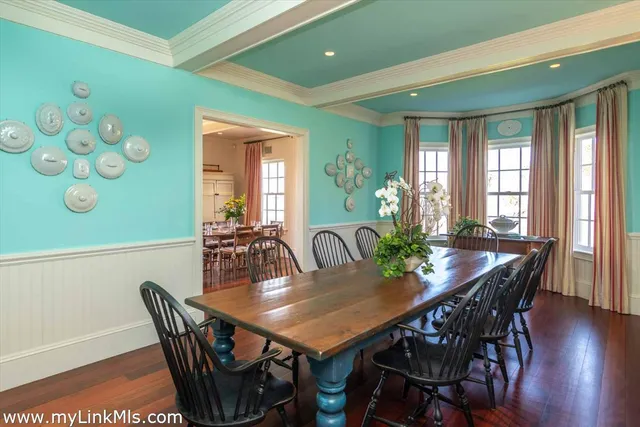 a view of a dining room and livingroom with furniture wooden floor a chandelier