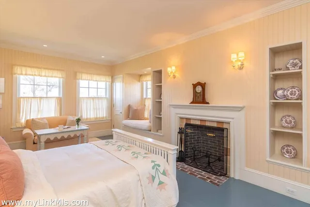 a spacious bedroom with a bed a table in it and a large window