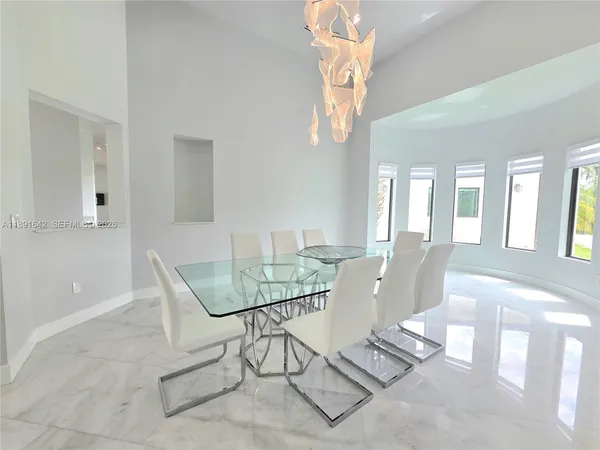 a view of an empty room with a window and a kitchen