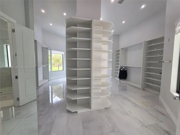 a large kitchen with kitchen island a dining table chairs and a refrigerator