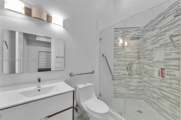 a spacious bedroom with a balcony a large bed and a potted plant