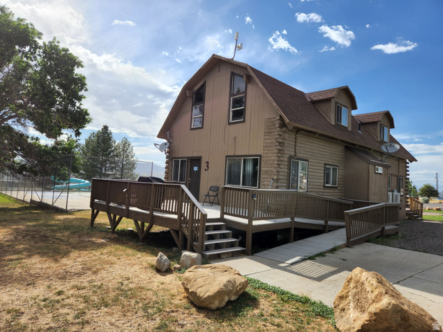 12615 Cedar Ridge Drive, Unit C41 Fairview, UT 84629 - Photo 25 of 32 Back of house featuring a wooden deck, a gambrel roof, log exterior, and a shingled roof