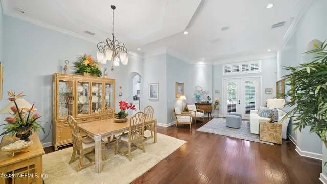 a view of a dining room with furniture a chandelier and wooden floor