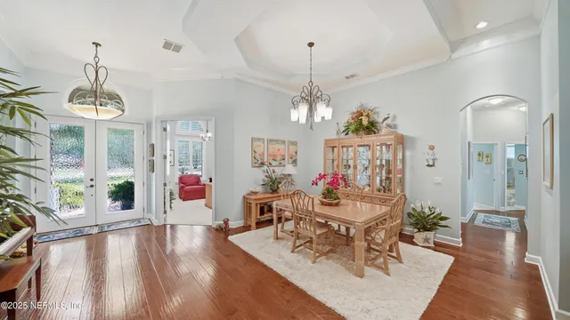 a kitchen with stainless steel appliances kitchen island granite countertop a table chairs in it and wooden floor