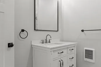 a bathroom with a sink vanity and a mirror