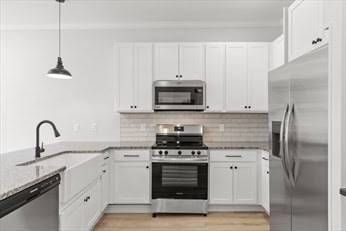 843 Main Street, Unit 104 Clinton, MA 01510 - Photo 4 of 19 a kitchen with white cabinets stainless steel appliances and a sink