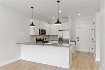 843 Main Street, Unit 104 Clinton, MA 01510 - Photo 8 of 19 a view of a kitchen with stainless steel appliances granite countertop a sink a refrigerator and a wooden floor