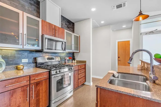 a room with stainless steel appliances kitchen island a table and chairs