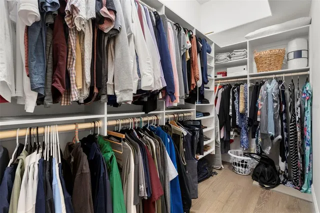 a view of walk in closet with clothes and shoes