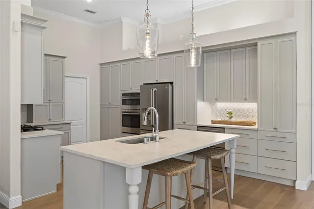 a kitchen with a table a refrigerator and cabinets