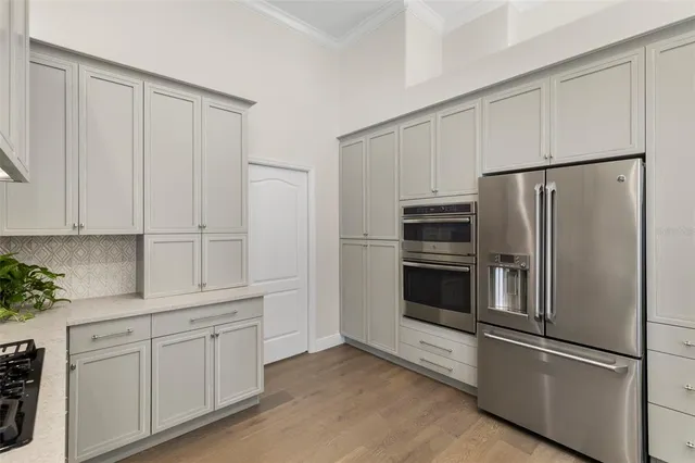 a kitchen with white cabinets and stainless steel appliances