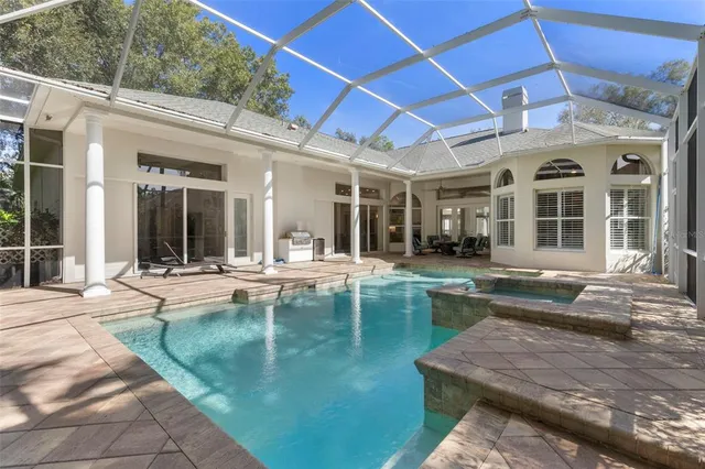 a view of a house with swimming pool and sitting area