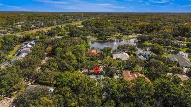 an aerial view of residential houses with outdoor space and trees
