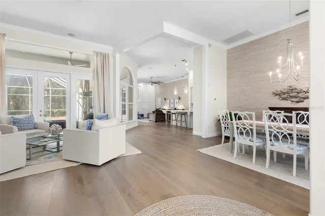 a living room with furniture and a dining table with wooden floor