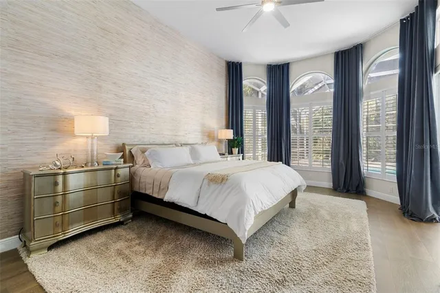 a bedroom with a bed and large windows