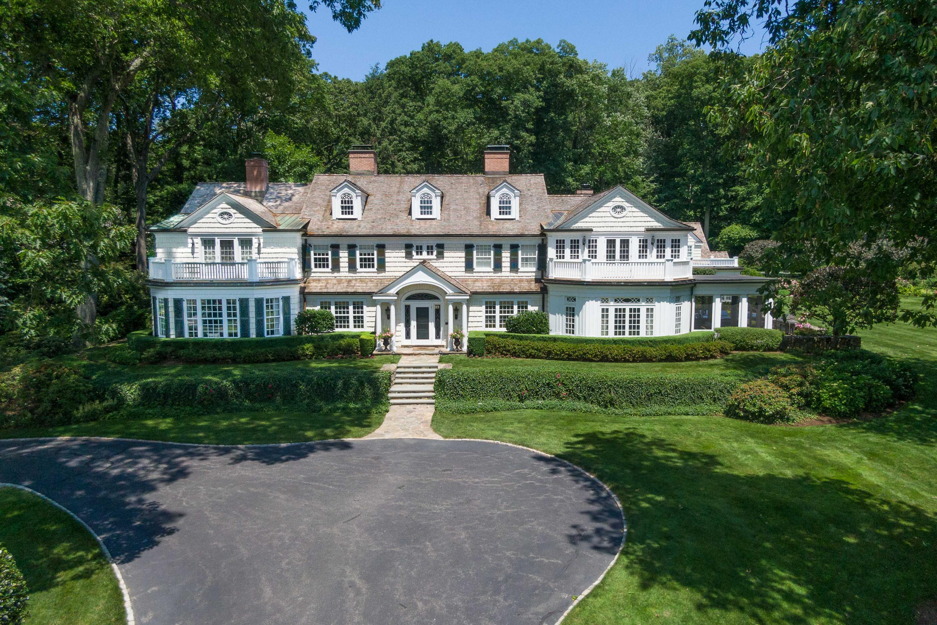 707 West Road New Canaan, CT 06840 - Photo 3 of 58 a front view of a house with a yard table and chairs
