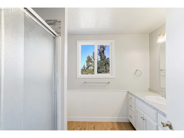 a bathroom with a granite countertop sink a vanity and a shower