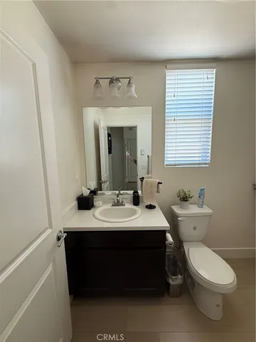 a bathroom with a toilet a sink and mirror