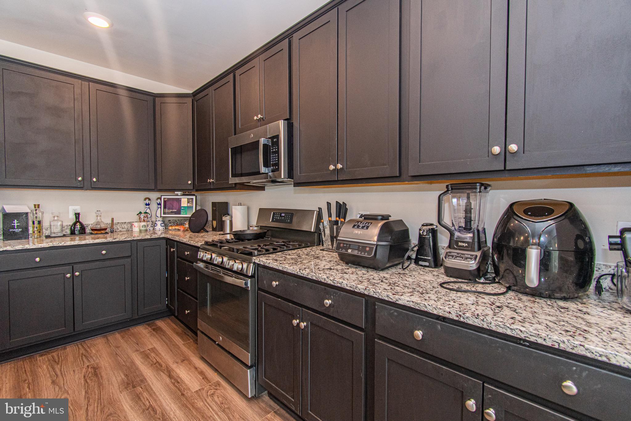 9637 Block Street Lanham, MD 20706 - Photo 17 of 47 a kitchen with granite countertop a sink a stove and cabinets