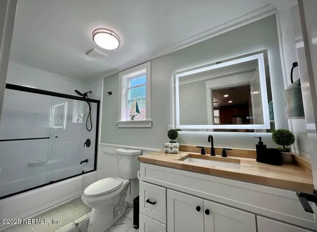 a bathroom with a sink a toilet and a large mirror