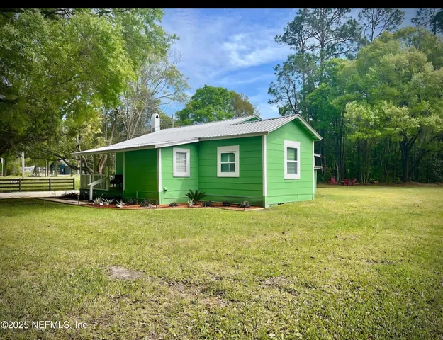 a view of a house with backyard and garden