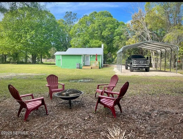 a backyard of a house with table and chairs